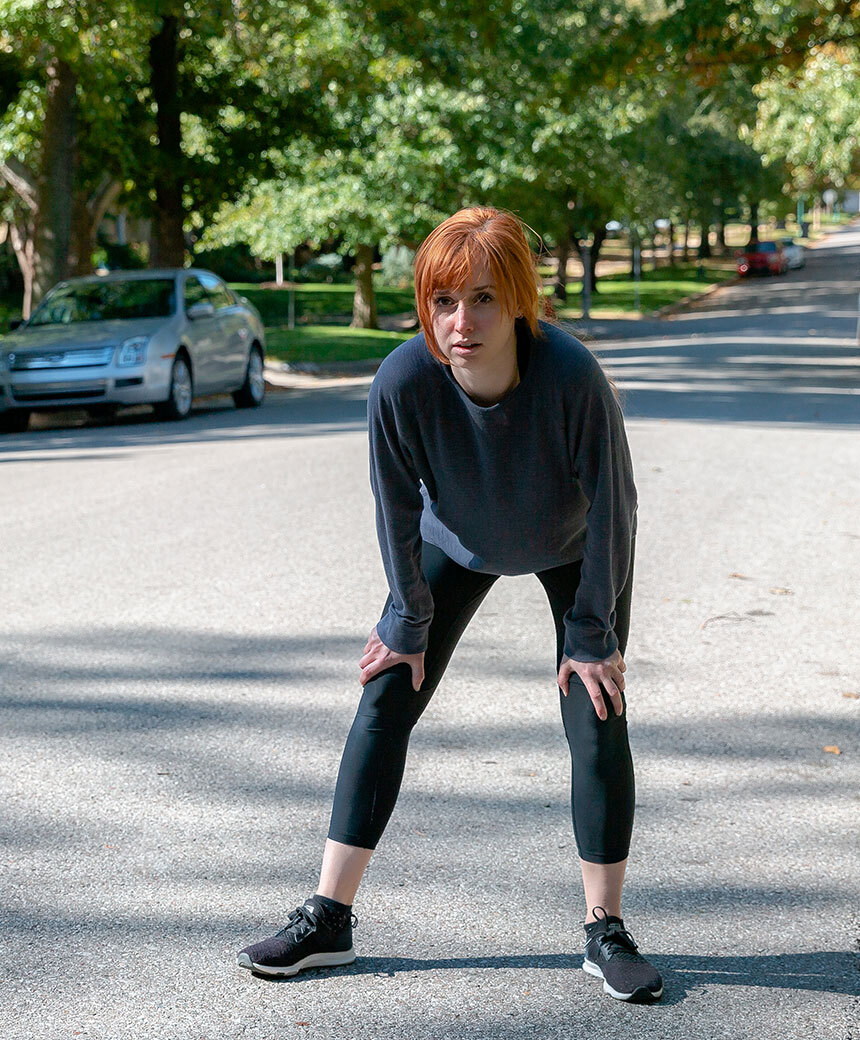 Exhausted runner on the street considers going to the doctor